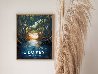 A framed poster of Lido Key Mangroves hangs on a wall, depicting sunlit water and arching mangrove canopies. Dried grasses are arranged next to it, enhancing the natural aesthetic.