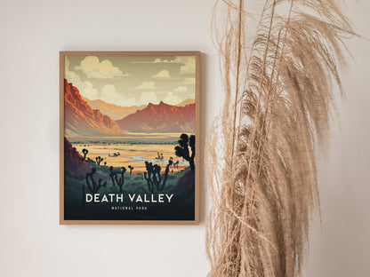 A framed Death Valley National Park print hangs on a wall, depicting a vibrant desert landscape with mountains and Joshua trees. Nearby, dried ornamental grass adds a natural touch.