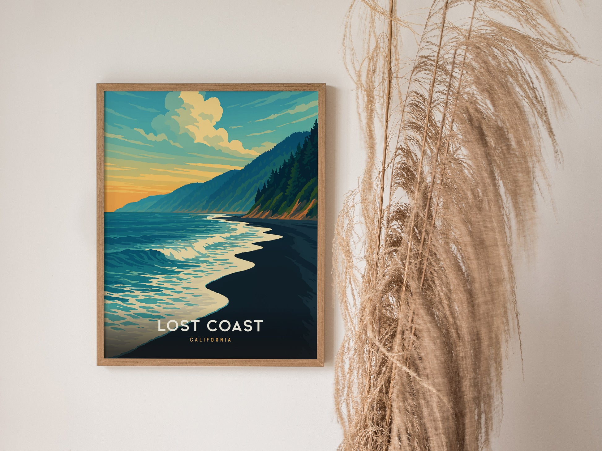 Framed Lost Coast California poster showcases a vibrant ocean scene with crashing waves, forested hills, and a warm sunset sky.