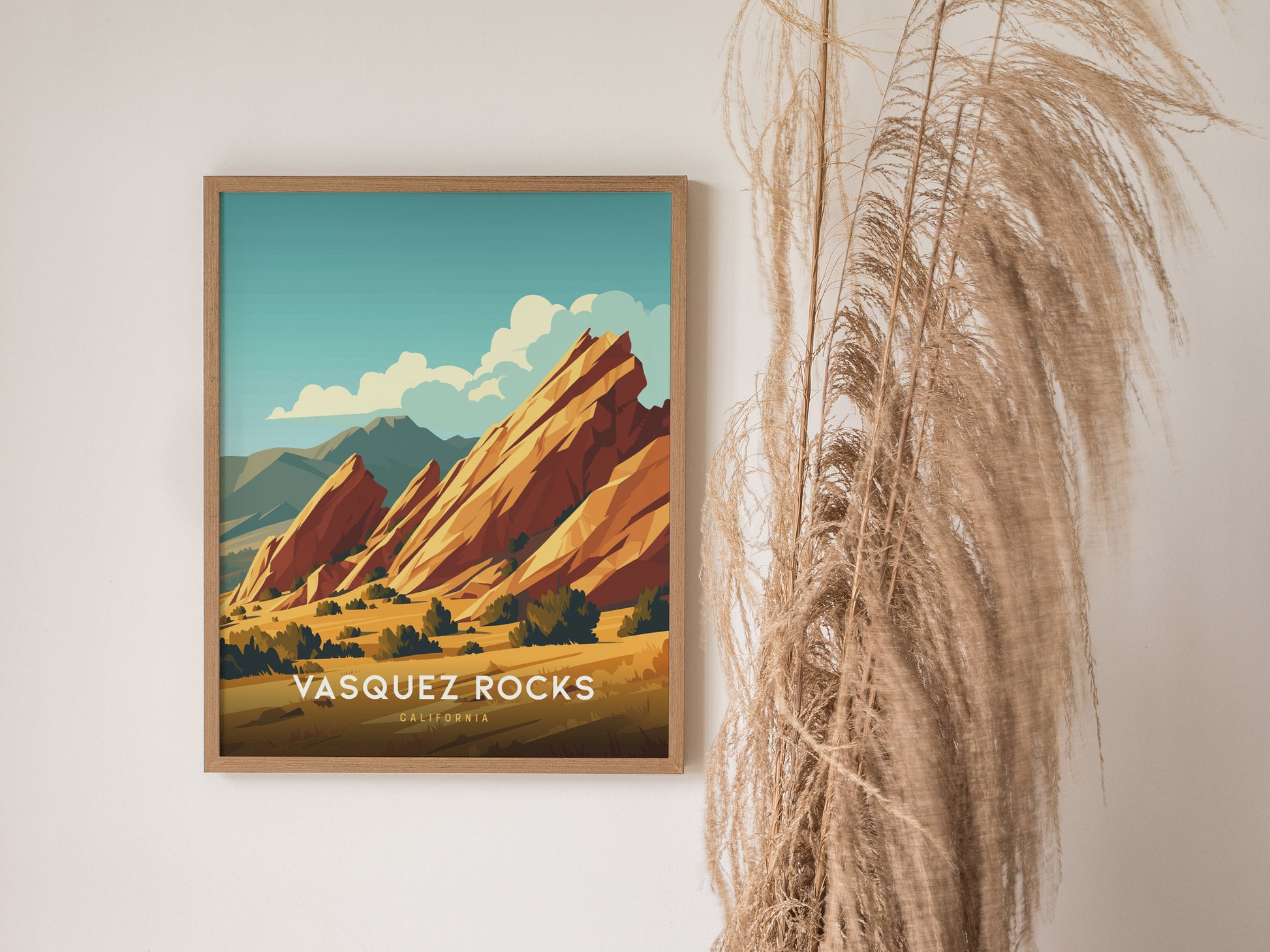 Framed Vasquez Rocks poster with vibrant, tilted sandstone formations against a blue sky. Dry pampas grass decorates the right side, enhancing the minimalist aesthetic.