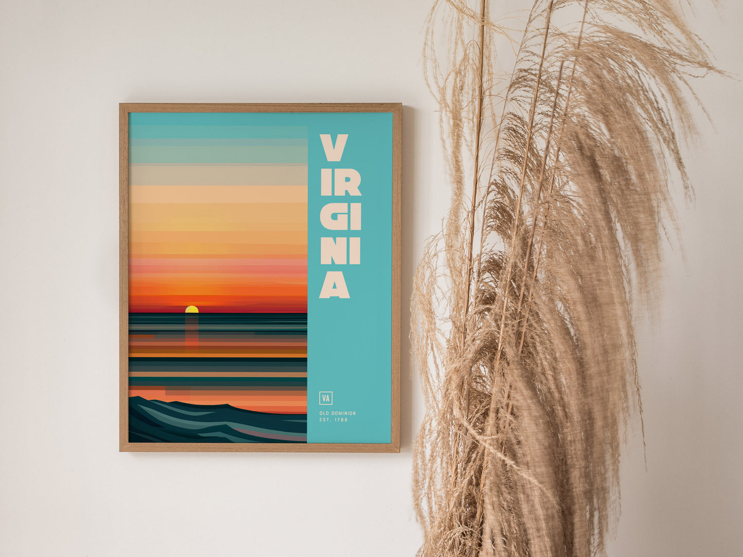 A framed poster with a stylized sunset over the ocean and the word Virginia on a blue background, alongside tall dried grasses.