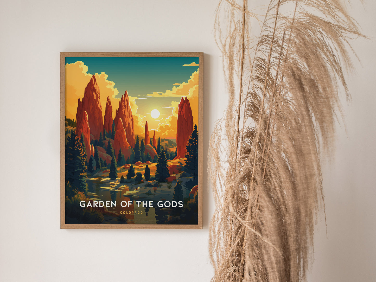 A framed poster titled Garden of the Gods showcases vibrant red rock formations against a sunset sky, with decorative pampas grass beside it.