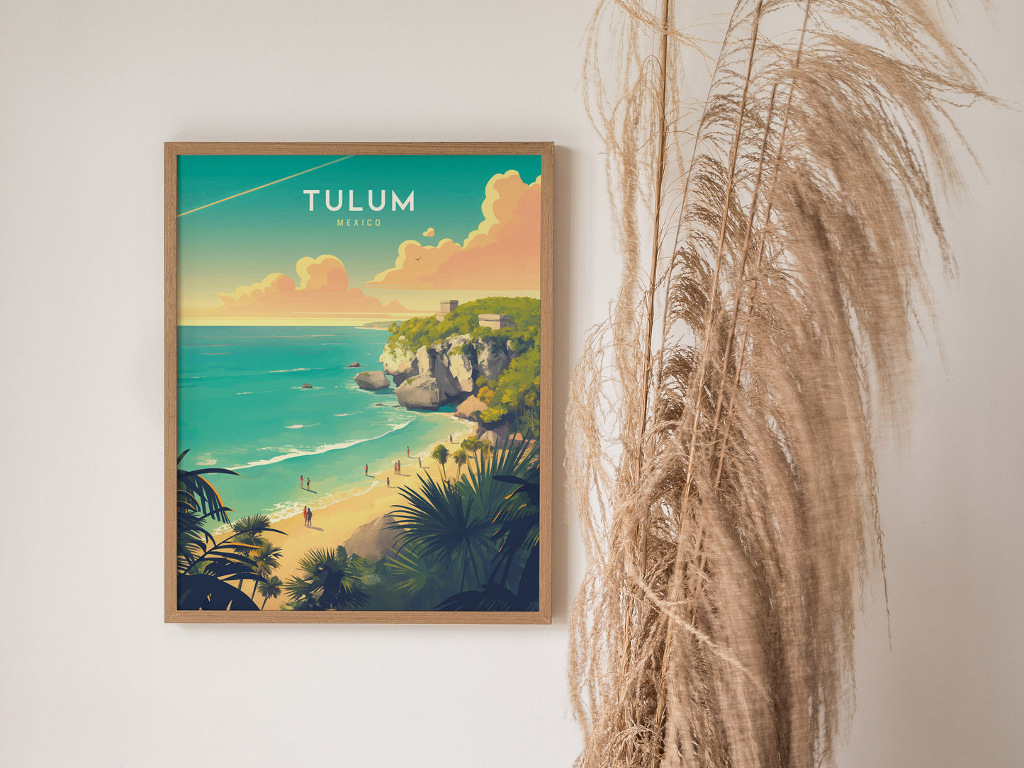 Framed poster of Tulum, Mexico, depicting vibrant turquoise waters, sandy beaches, and Mayan ruins on cliffs, next to decorative dried grasses. The artwork captures a tropical, serene atmosphere.