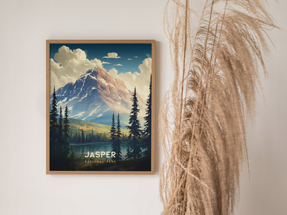 A framed poster of Jasper National Park features a mountain landscape with pine trees and clouds. Its displayed on a white wall next to dried pampas grass.