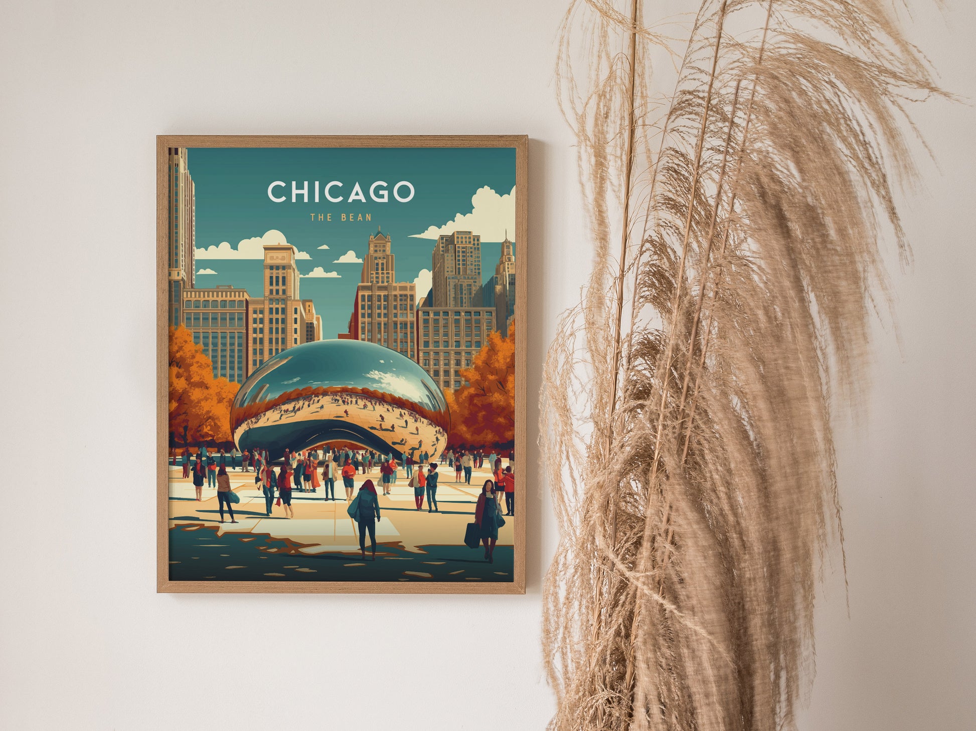A framed poster of Chicagos Cloud Gate, featuring vibrant colors and autumn trees, hangs on a wall beside tall, dried plants.