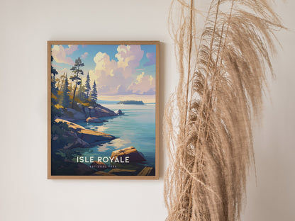 A framed Isle Royale National Park poster featuring a scenic view of rocky shorelines and pine trees by a calm lake, with pampas grass decor nearby.