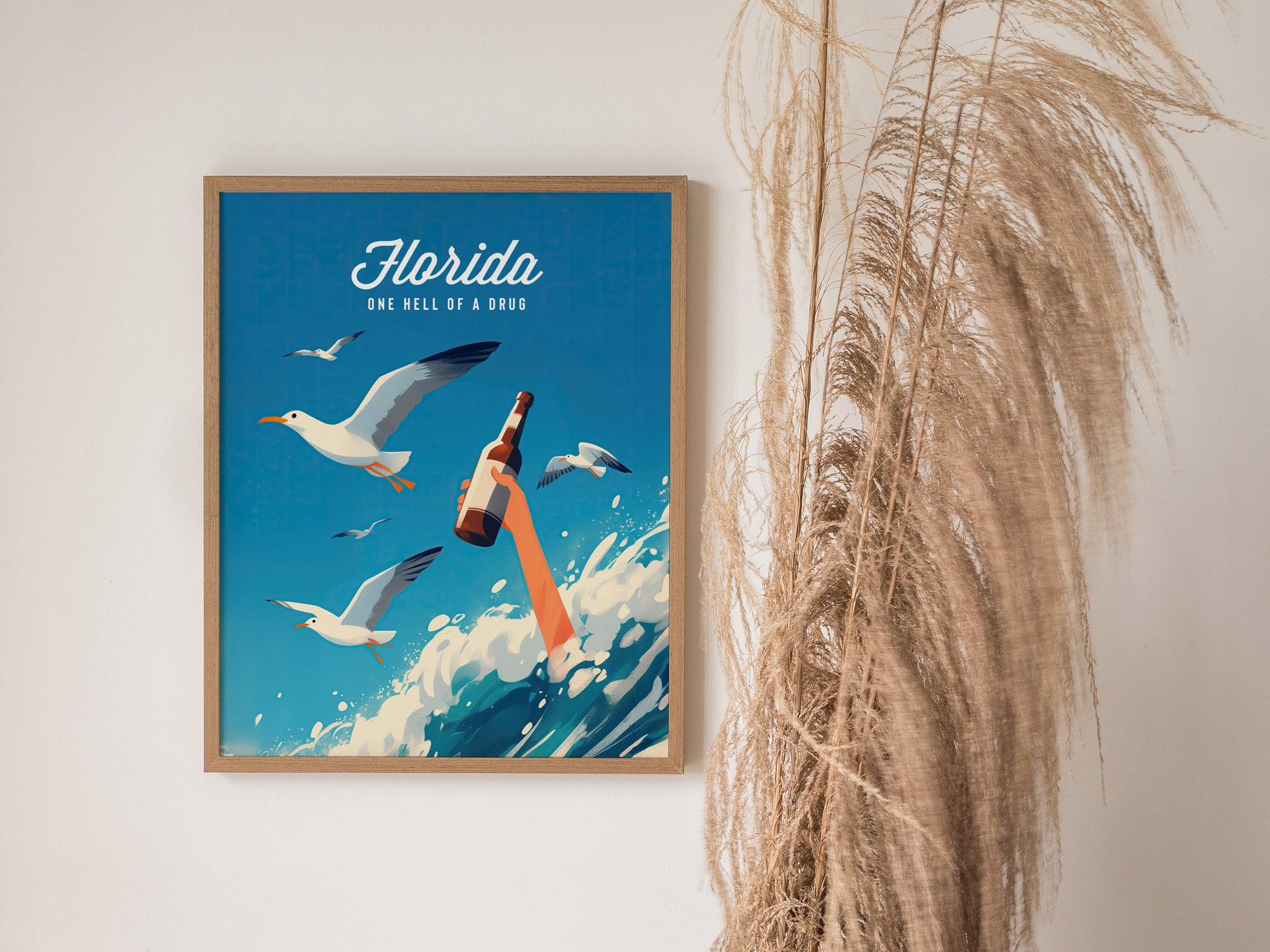 A framed poster with seagulls flying over ocean waves, featuring a hand holding a beer bottle, and the text Florida - One Hell of a Drug against a blue background.