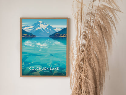 A framed poster of Colchuck Lake, Washington, features turquoise waters and snow-capped mountains, with pampas grass decoratively placed beside it.