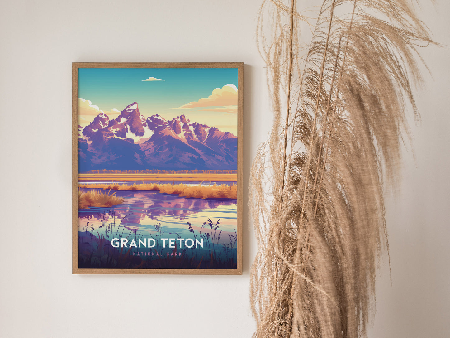 A framed poster of Grand Teton National Park hangs on a wall, depicting vibrant mountain peaks and a reflective lake, alongside decorative dried grasses.