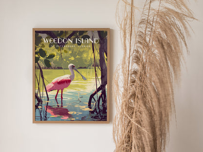 A framed poster features a vibrant pink Roseate Spoonbill wading in tranquil waters with lush greenery, titled Weedon Island, St Petersburg, Florida, next to decorative dried grasses.