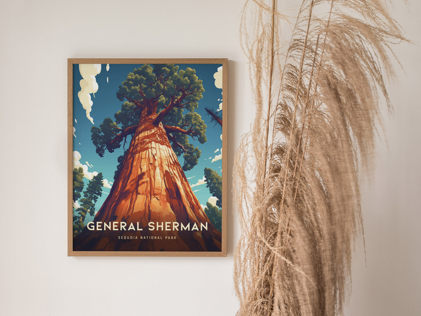 A framed poster of the General Sherman Tree from Sequoia National Park hangs on a wall, with dried pampas grass decoratively placed beside it.