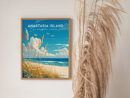 A framed poster of Anastasia Island, St. Augustine, Florida, featuring sea oats, waves, and seabirds in flight, hangs on a wall beside tall, dried grasses.