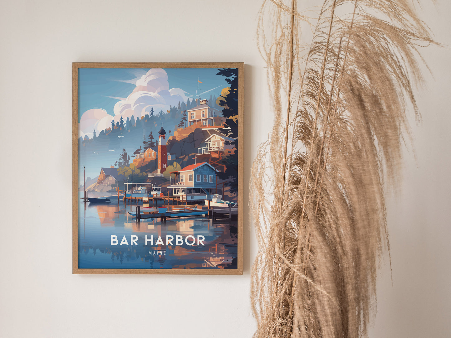 A framed poster of Bar Harbor, Maine features a scenic coastal view with houses, a lighthouse, and boats on calm waters, set against a backdrop of trees and clouds.