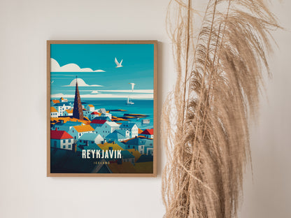 A framed travel poster of Reykjavík, Iceland, featuring colorful buildings and a tall church spire against a sea view, hangs on a white wall beside tall, dried grasses.