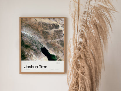 Framed Joshua Tree satellite poster featuring a detailed aerial view of desert terrain, mountains, and a contrasting dark water body, ideal travel art.