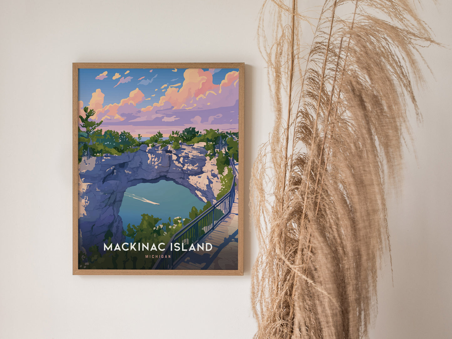 A framed poster of Mackinac Islands Arch Rock hangs on a wall, depicting a vibrant landscape with cliffs, trees, and a blue lake under a colorful sky.
