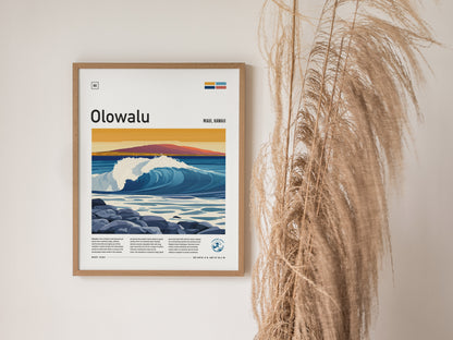A framed Olowalu Maui surf poster featuring vibrant ocean waves and a mountainous sunset is displayed on a wall next to decorative pampas grass.