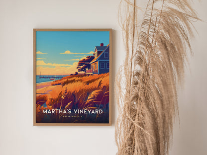 Framed Marthas Vineyard poster featuring a coastal scene with a house, golden grasses, and sailboats on the horizon, displayed on a wall next to decorative pampas grass.