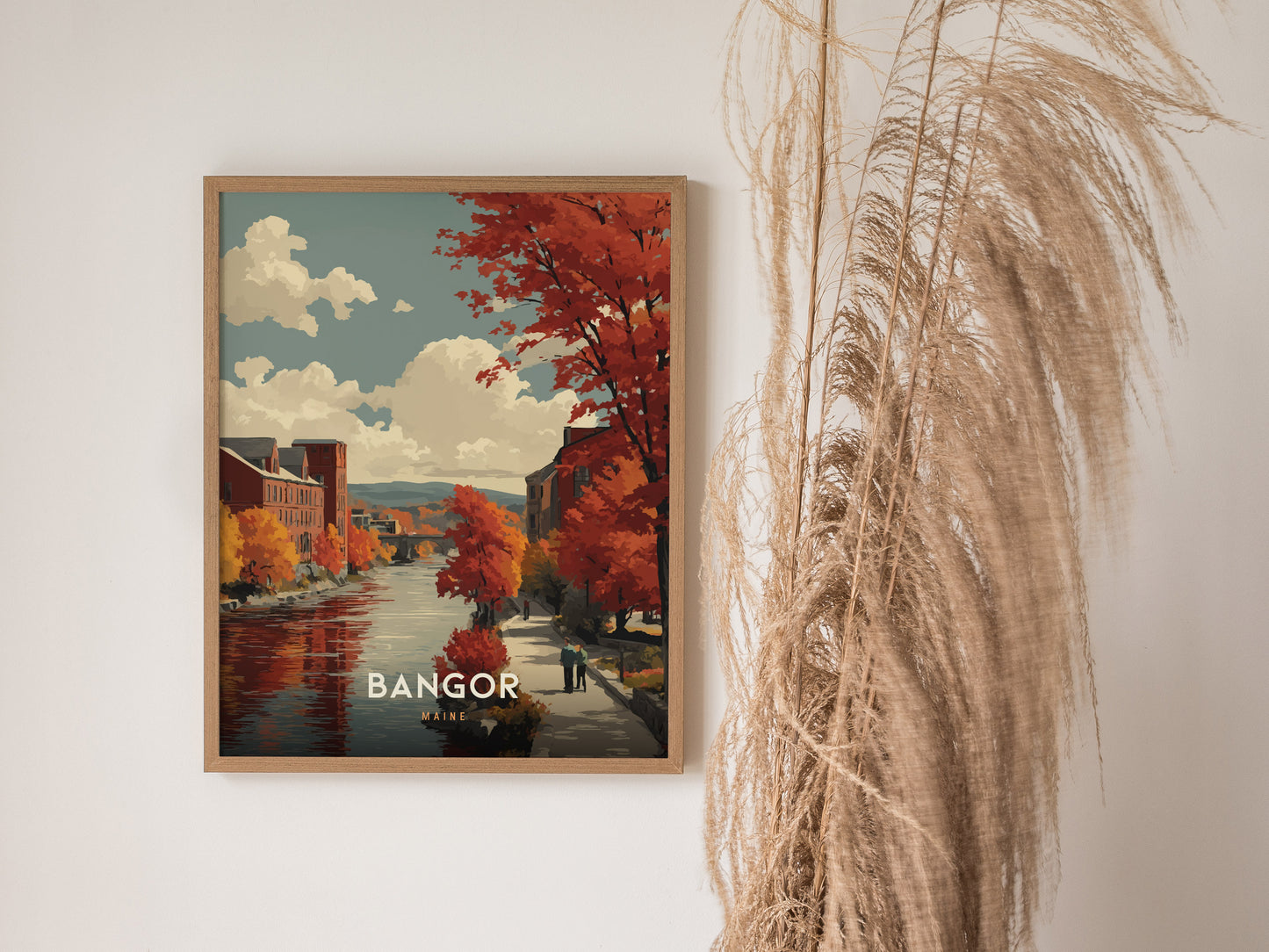 Autumn river scene from Bangor, Maine, featuring vibrant foliage, historic buildings, and a serene walkway in warm hues. Travel art print by Swell Scenes.