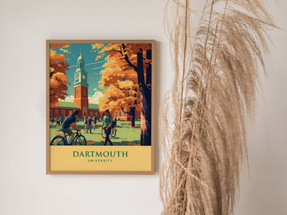 A framed Dartmouth University poster featuring a campus scene with students, bicycles, and autumn trees, hangs on a white wall beside dried pampas grass.