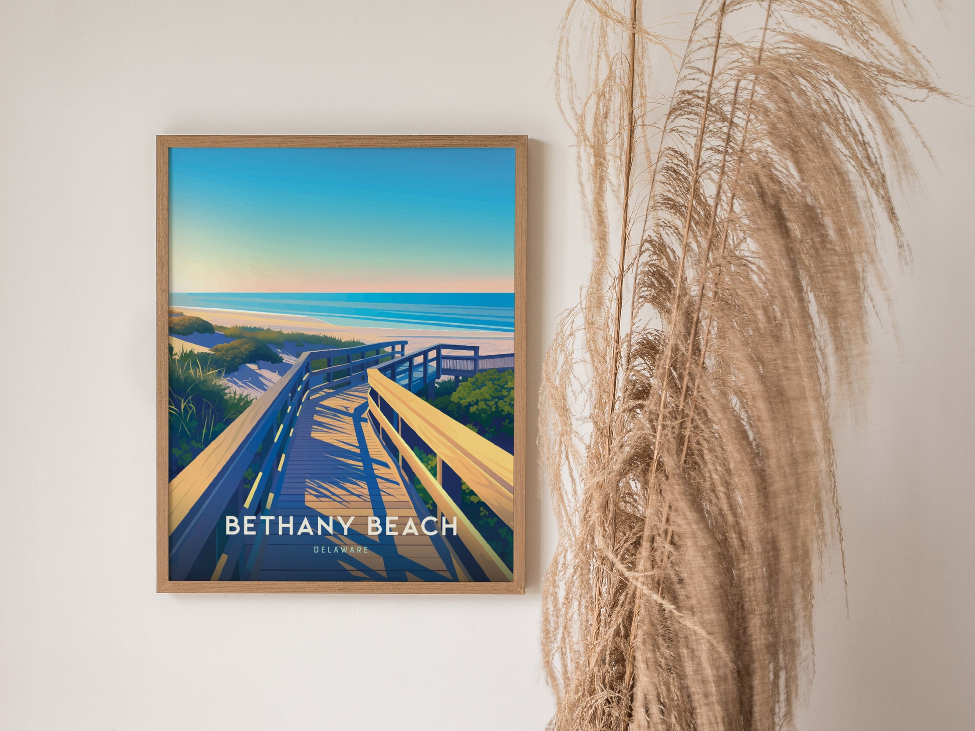 The image shows a framed Bethany Beach poster featuring a wooden boardwalk leading to the ocean under a blue sky, with decorative grasses beside it.
