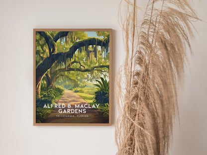 A framed poster of Alfred B. Maclay Gardens in Tallahassee, Florida, features a scenic path framed by lush green trees. Dried pampas grass decorates the adjacent wall.