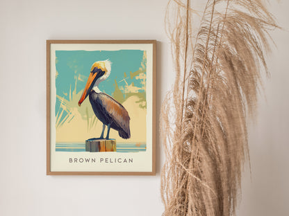 A framed poster of a brown pelican perched on a post against a stylized background is displayed next to dried pampas grass.