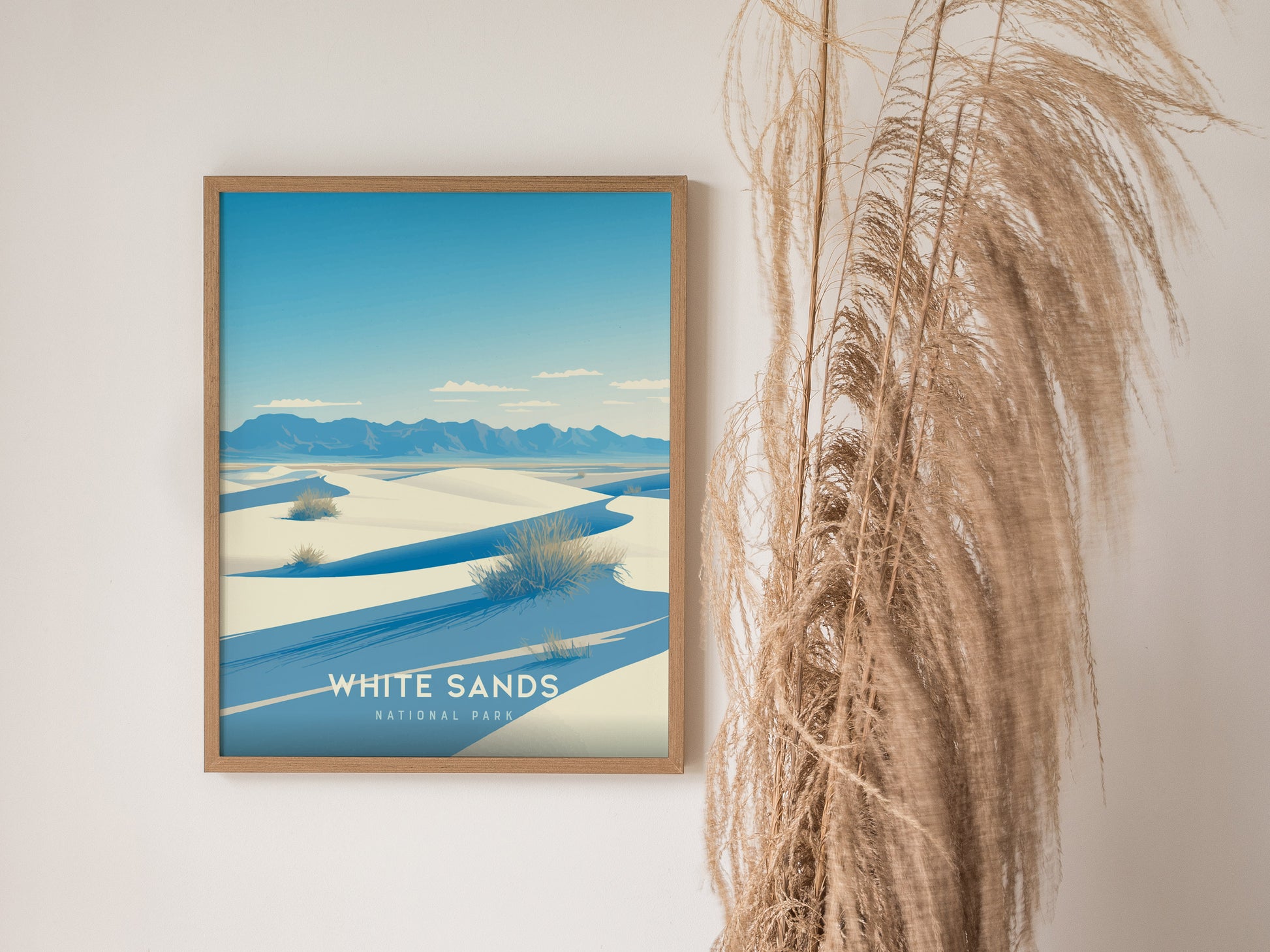 A framed poster of White Sands National Park features white dunes under a blue sky, with mountains in the background. Pampas grass decorates the right side of the scene.