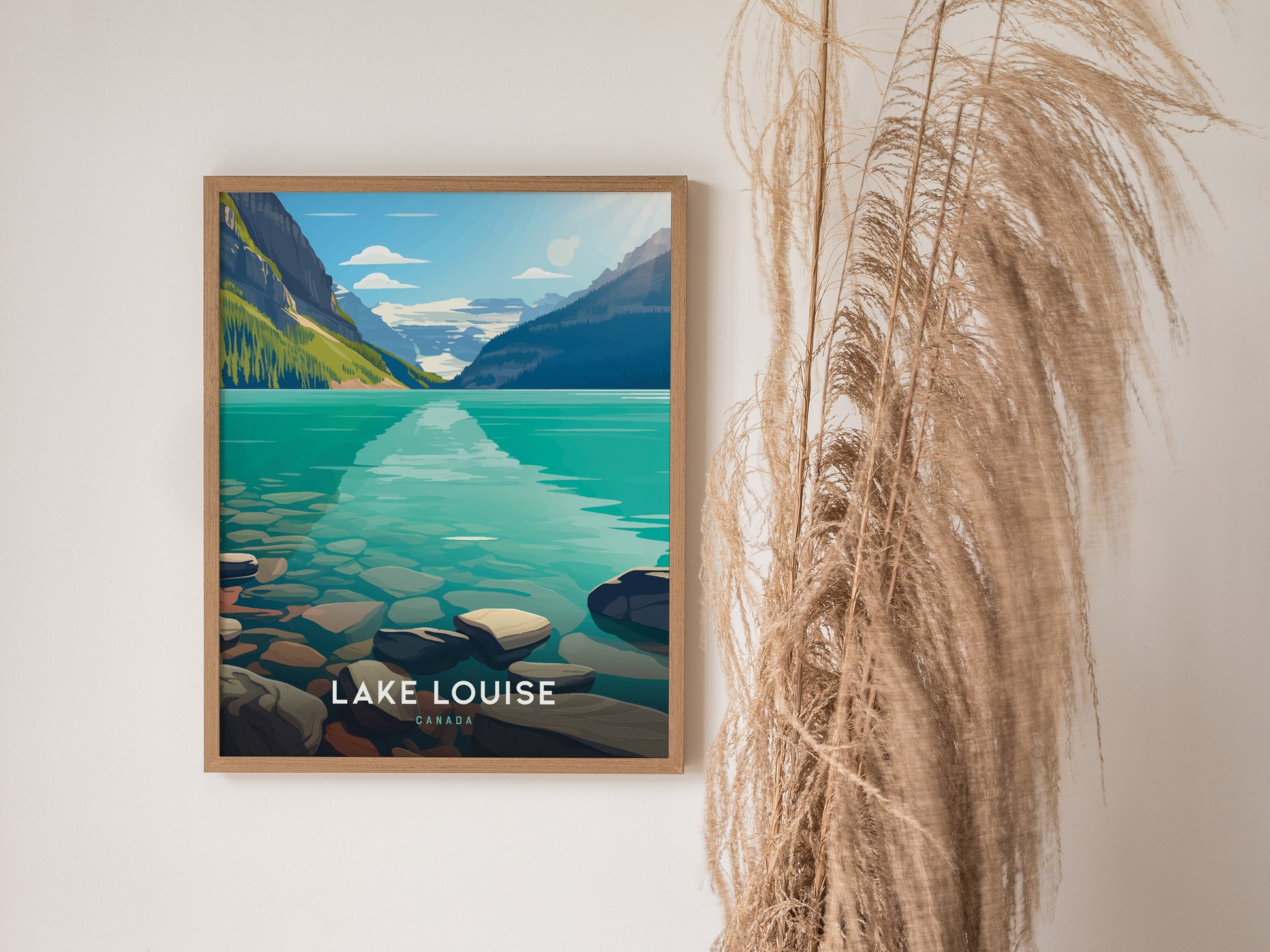 A framed poster of Lake Louise with turquoise waters and distant mountains is displayed on a white wall, accompanied by tall.