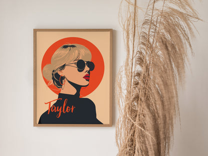 A framed poster features a minimalist illustration of a woman in sunglasses against a bright orange circle, with the name Taylor written below. Tall pampas grass decorates the right side.