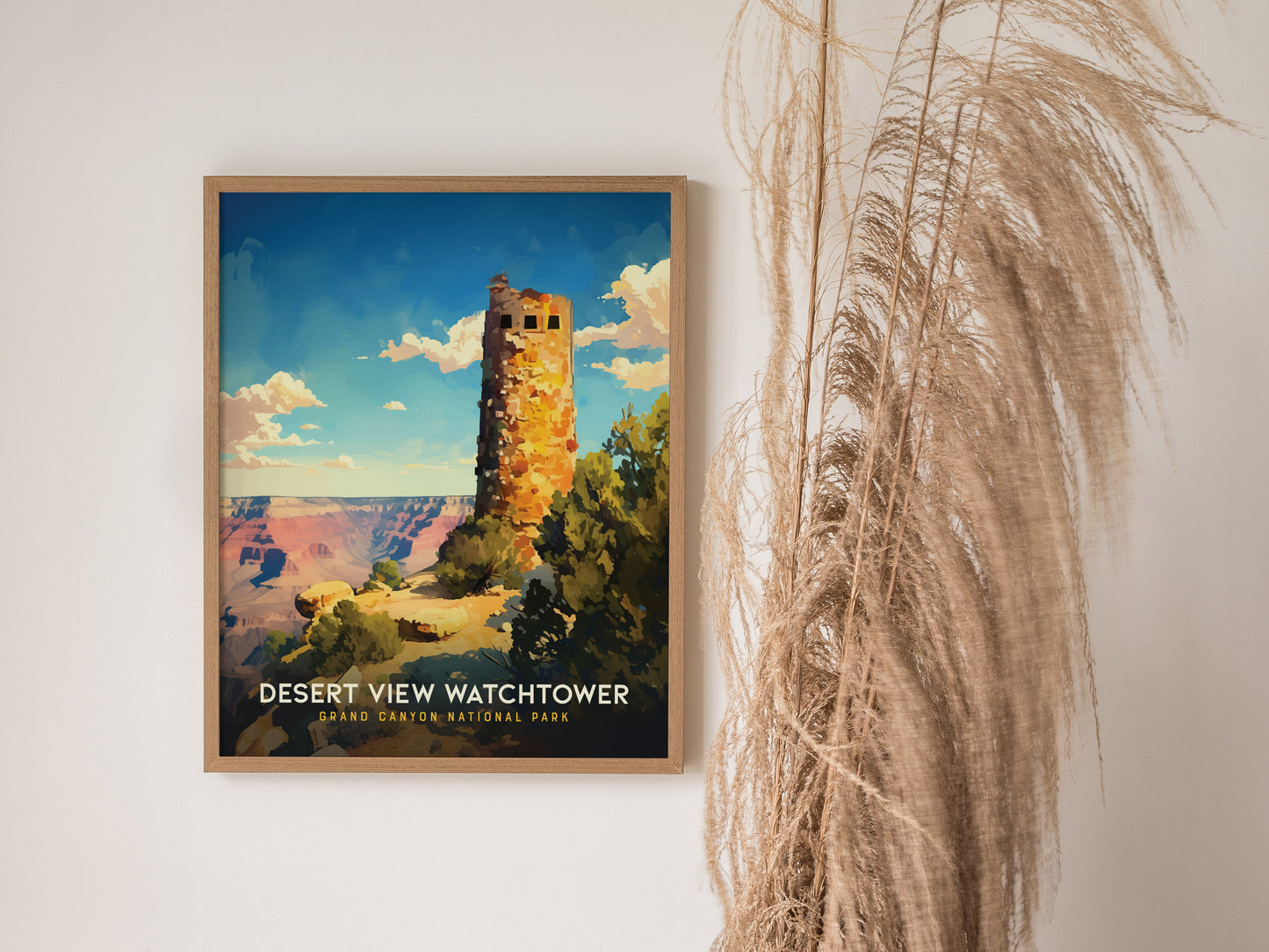 Framed Desert View Watchtower poster with vibrant colors depicting the Grand Canyon, displayed on a white wall next to tall, dried pampas grass.