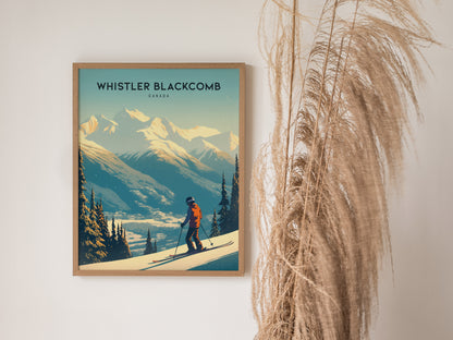 A framed poster of Whistler Blackcomb features a skier on snowy slopes with towering mountains in the background, displayed beside tall, wispy pampas grass.