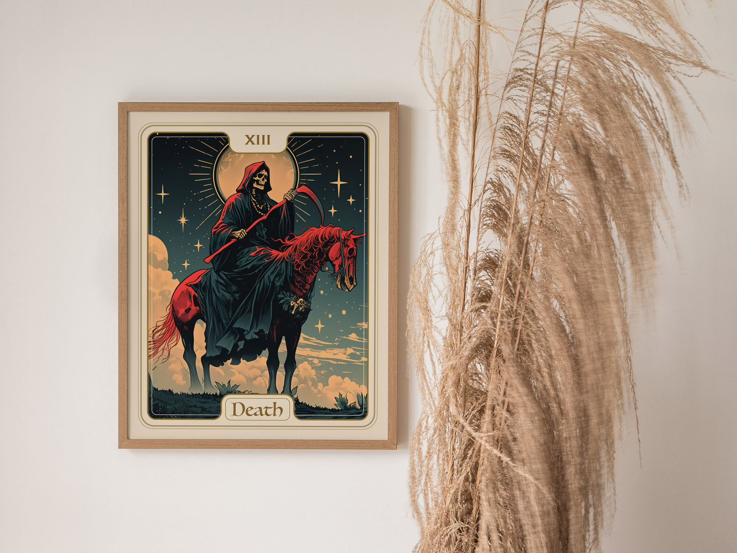 Framed Art Nouveau poster of the Death tarot card, featuring a skeletal rider on a red horse beneath a starry sky, hangs on a wall beside tall dried grasses.