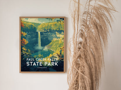A framed poster of Fall Creek Falls State Park, featuring a vibrant illustration of the waterfall surrounded by lush greenery, is displayed on a wall beside tall, wispy dried grass.