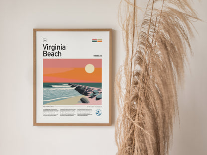 A framed poster of Virginia Beach features a stylized sunset over a rocky jetty and ocean waves, alongside decorative dried grasses.