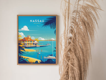 A framed Nassau Bahamas poster depicting a vibrant coastal scene with turquoise waters and palm trees, set against a white wall with tall, dried ornamental grass beside it.