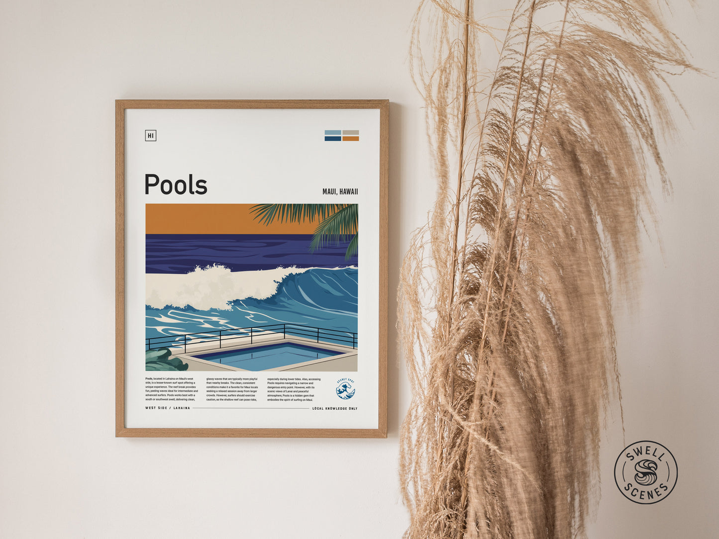 Framed artwork titled Pools depicts a vibrant ocean wave with a nearby pool, set against a tropical backdrop. Tall dried grasses are positioned beside the poster on a light wall.
