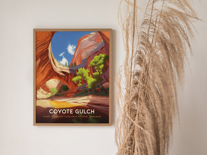 A framed poster of Coyote Gulch is displayed on a white wall, featuring vibrant canyon scenery with blue skies. Dried pampas grass decorates the space beside it.