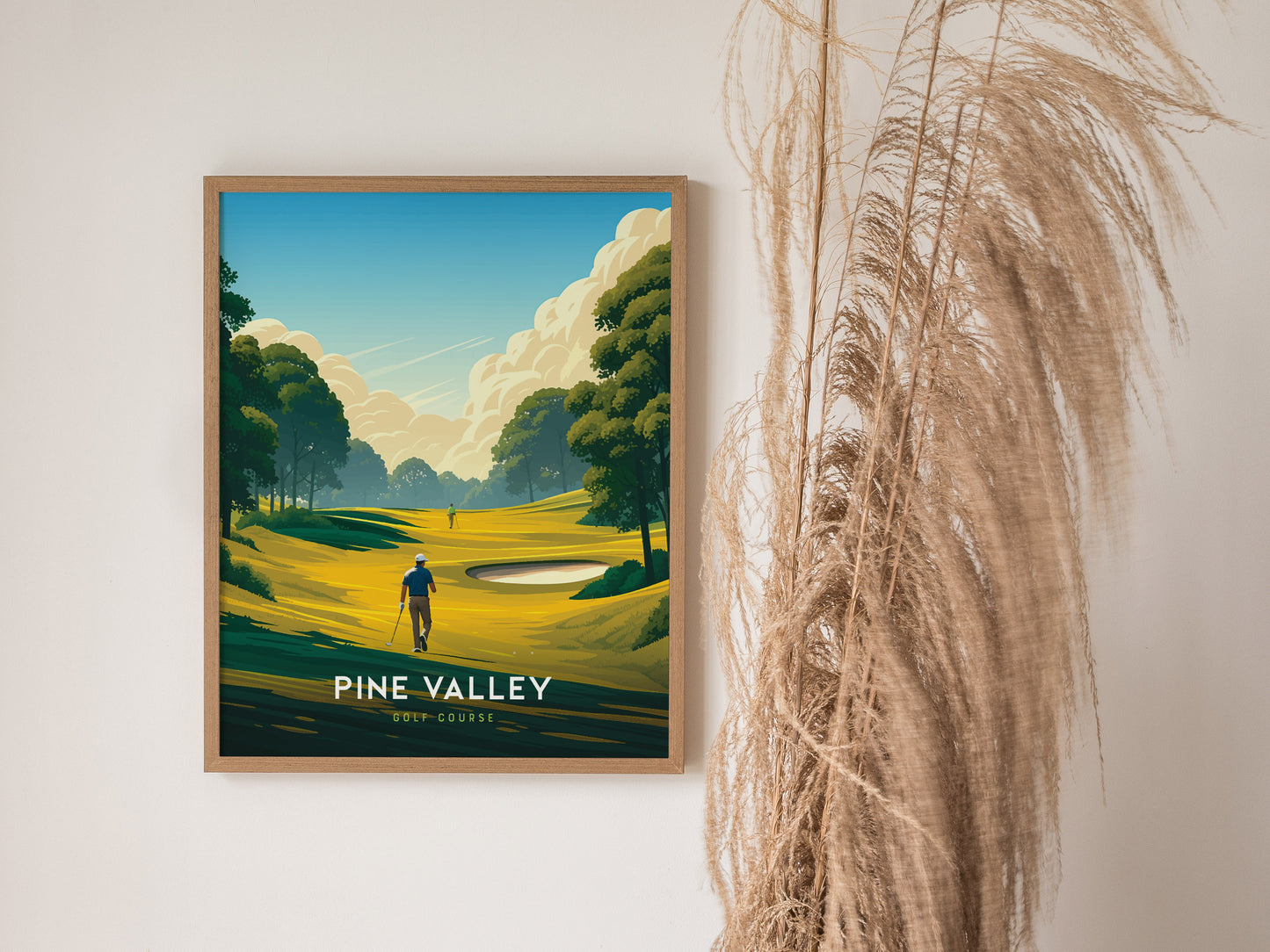 Framed Pine Valley Golf Course poster featuring a golfer on a vibrant, stylized fairway with lush trees and a sand trap, displayed beside tall, dried grasses.