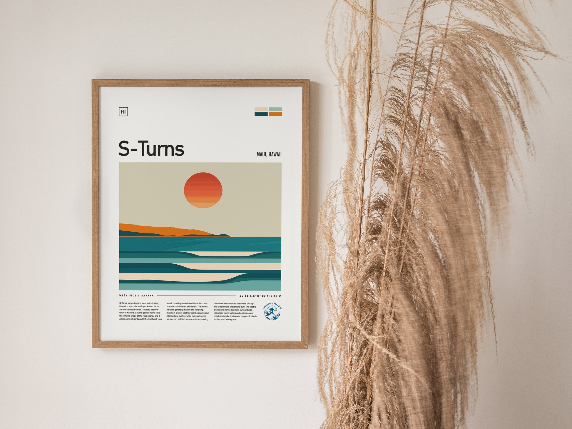 A framed S-Turns Maui poster features minimalist artwork of a sunset over ocean waves, with pampas grass decor placed beside it.