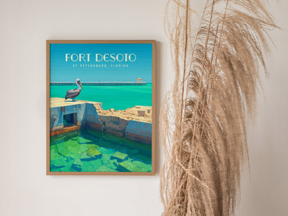A framed poster of Fort Desoto in St. Petersburg, Florida, featuring a pelican on fort ruins by turquoise waters, hangs on a wall next to tall dried grasses.