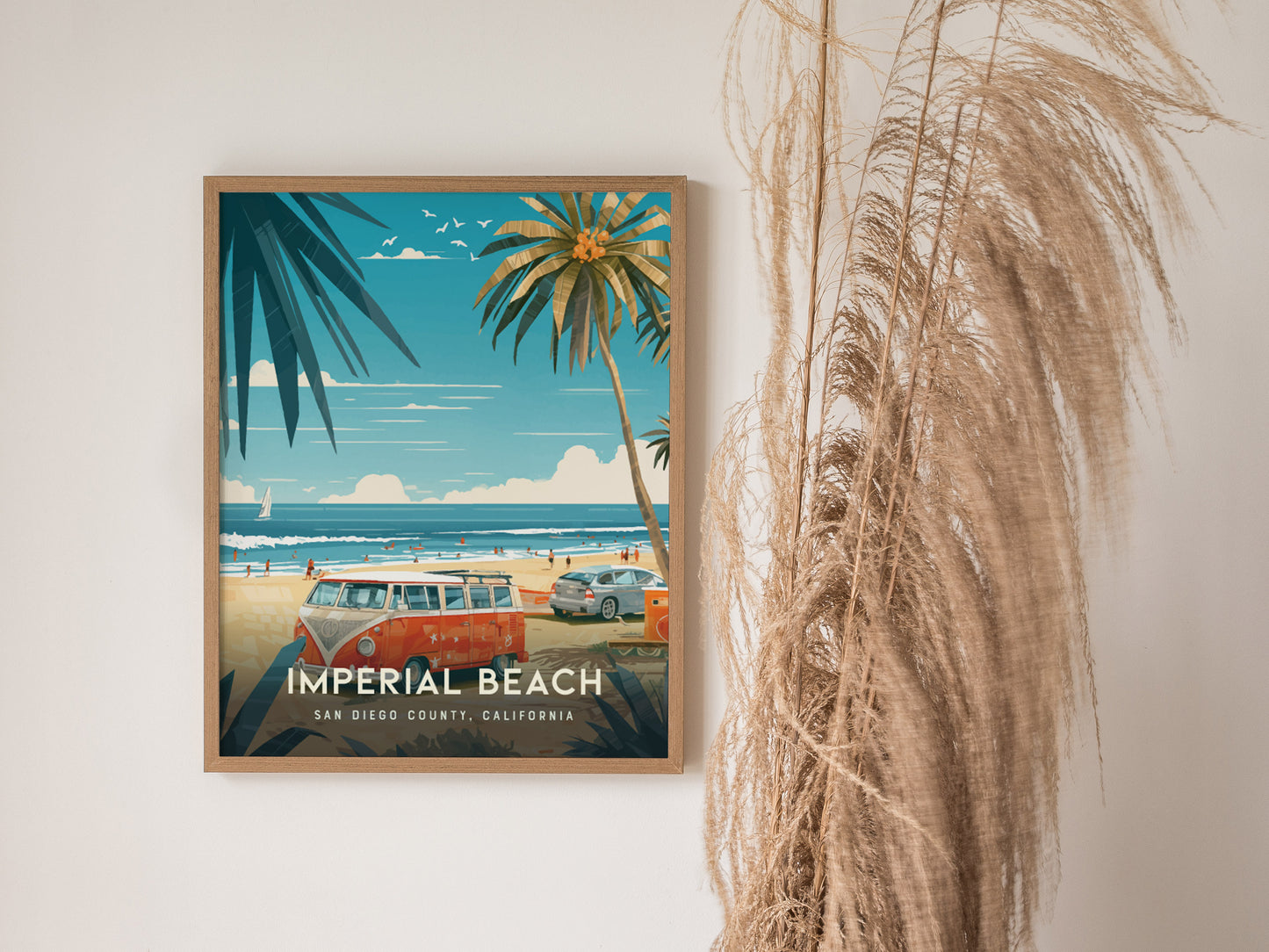 A framed poster of Imperial Beach, San Diego, features a beach scene with palm trees, a red van, and ocean waves, alongside decorative dried plants.