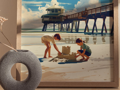 A framed poster depicts two children building a sandcastle on a beach with a pier and lifeguard tower in the background. A decorative vase is visible in the foreground.