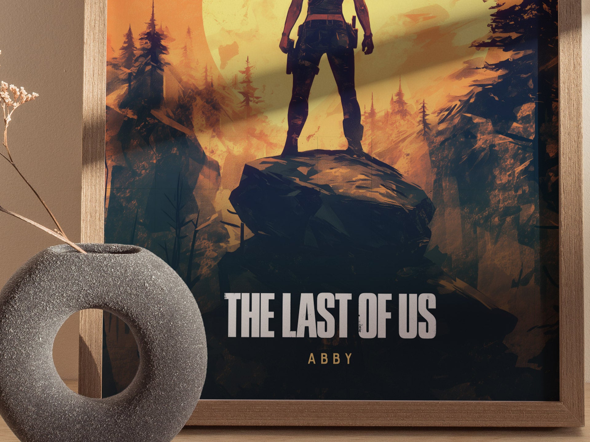A framed poster features a silhouette of a person standing on a rock in a forest, with the text The Last of Us Abby at the bottom.