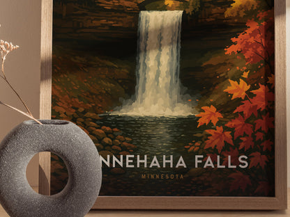 A framed poster of Minnehaha Falls features a waterfall cascading into a rocky creek, surrounded by autumn foliage. A gray, circular vase with dried flowers is in the foreground.