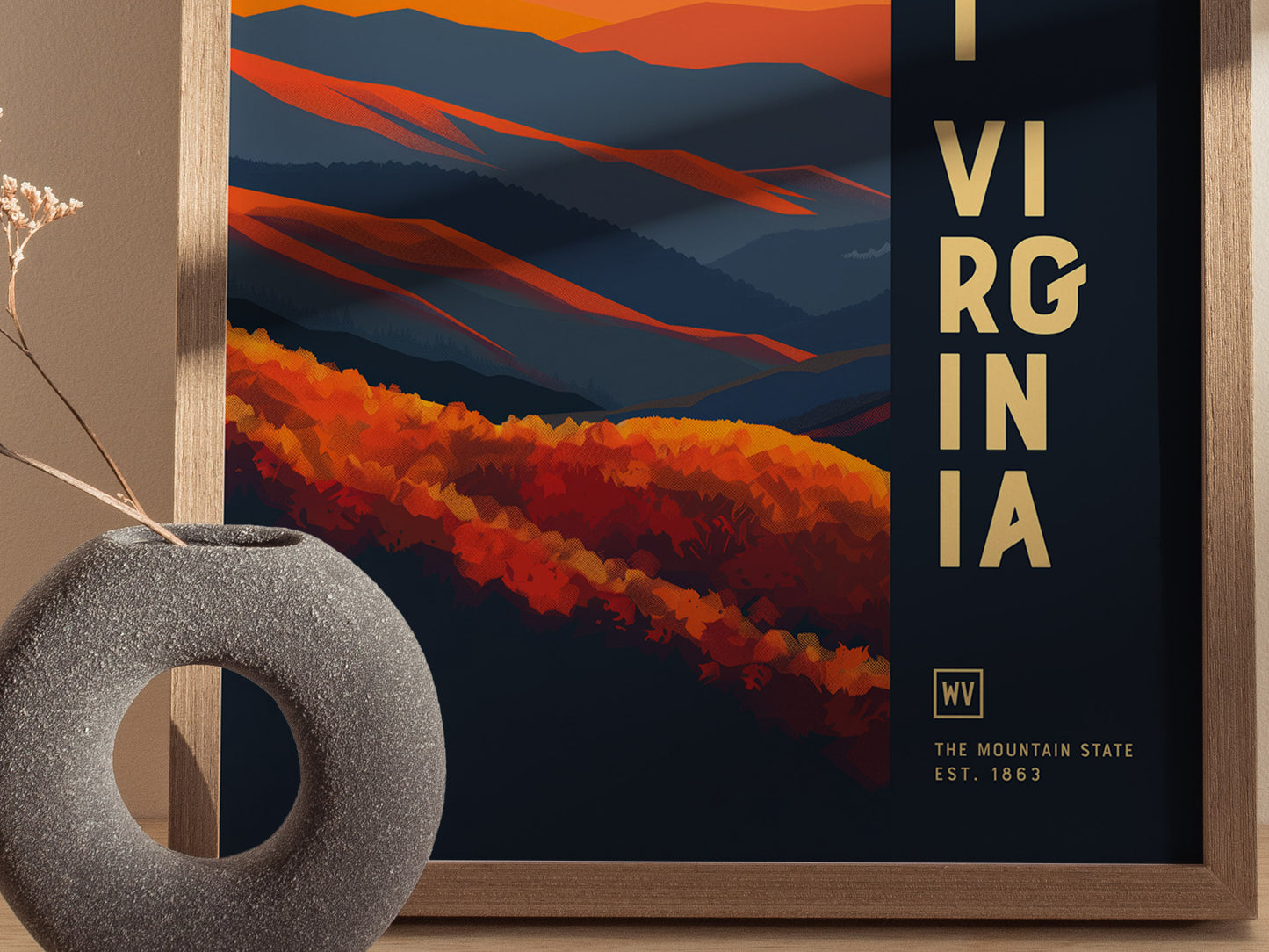 A minimalist poster of West Virginia featuring abstract geometric shapes in warm reds and blues, with bold typography. A textured, round vase sits nearby, enhancing the modern aesthetic.