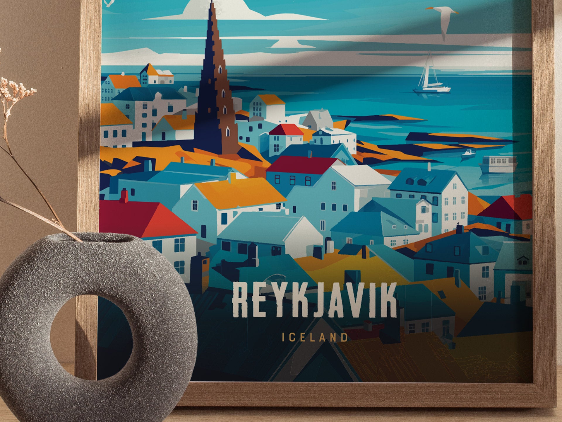 A colorful travel poster of Reykjavík, Iceland, featuring a stylized cityscape with vibrant rooftops and a tall church spire. A circular vase with dried flowers is in the foreground.