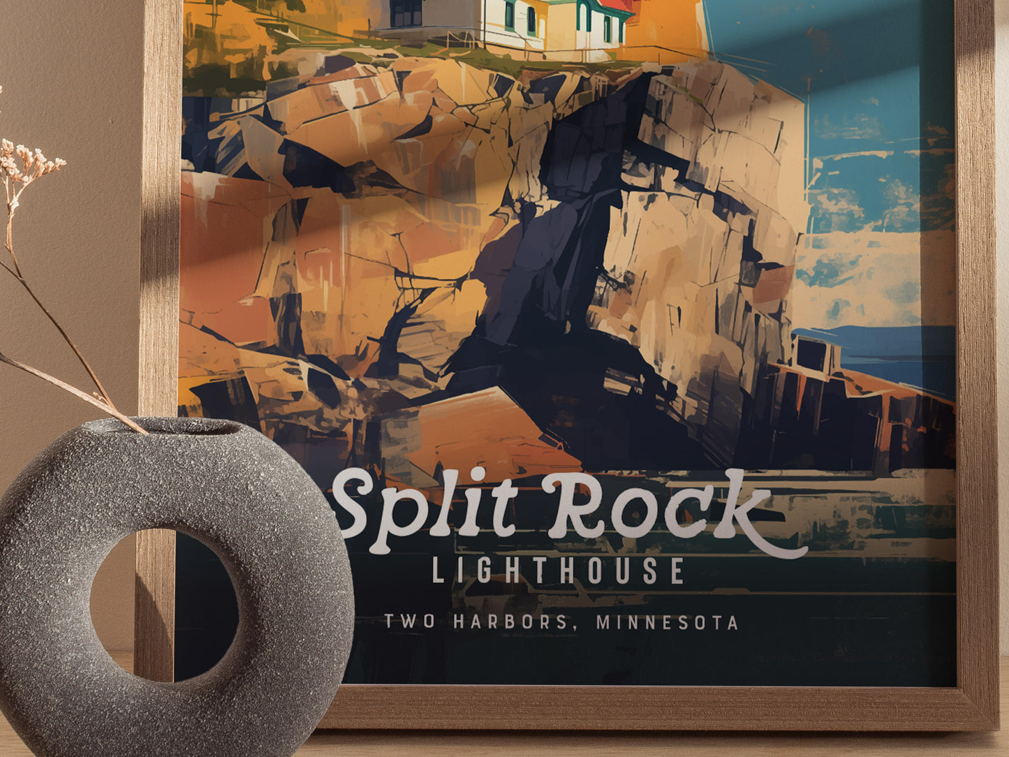 A framed poster of Split Rock Lighthouse with dramatic cliffs is displayed beside a round, textured vase. The artwork features bold colors and text reading Split Rock Lighthouse, Two Harbors,.