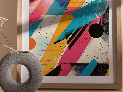 A framed 1980s-style abstract poster features vibrant geometric shapes in pink, blue, and yellow with black speckles. A textured gray vase with dried flowers is visible in the foreground.
