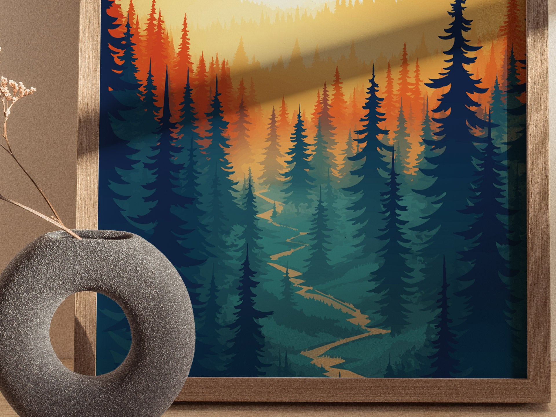 A framed poster features a stylized forest scene with a winding path, surrounded by vibrant orange and green trees. A textured round vase with dried branches sits beside it.